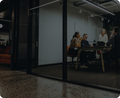 Meeting taking place in a modern glass walled office