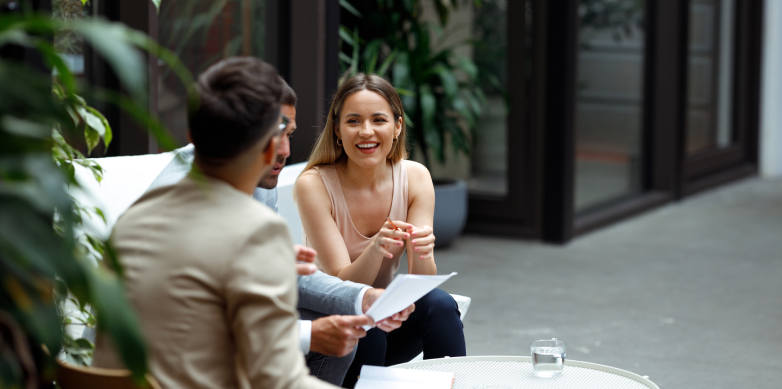 People sitting at an outside table discussing a business document